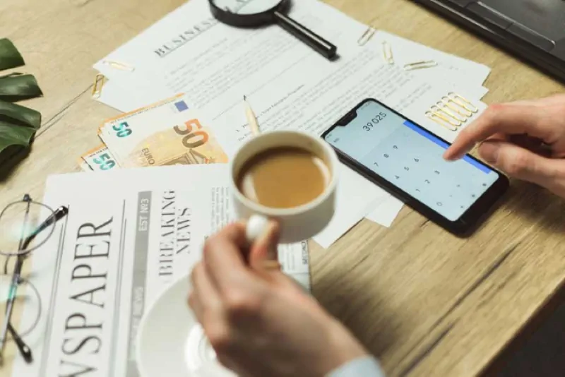Bere una tazzina di caffè in compagnia di uno smartphone